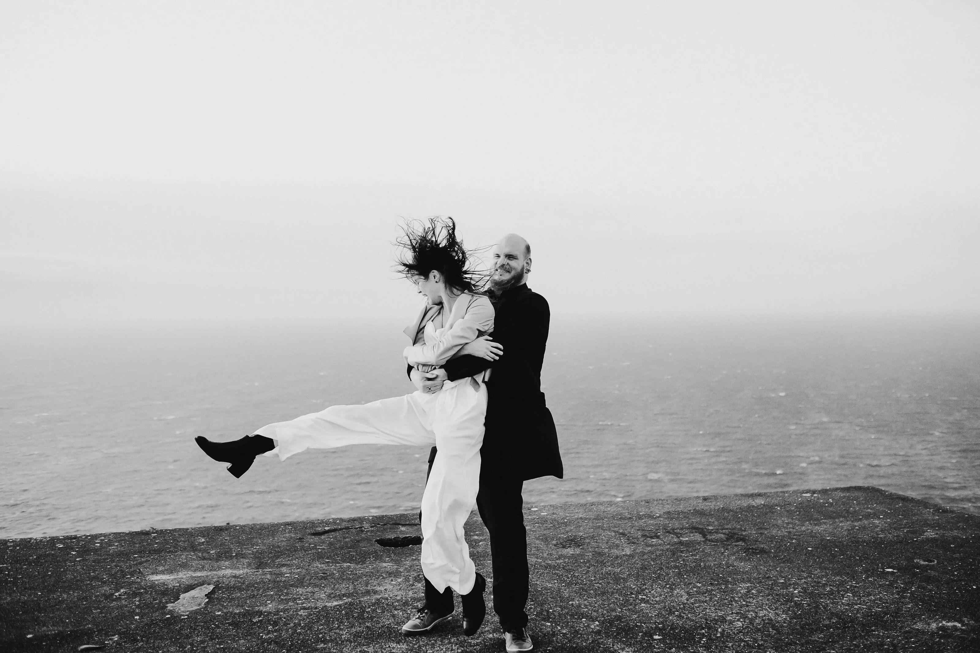 Couple embracing the wild Wellington weather during couple photoshoot