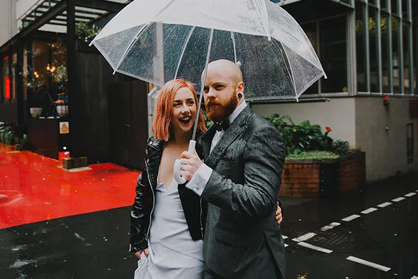 Georgina and Dylan happy in the rain on their wedding day.